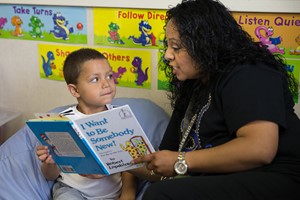 Teacher reading book to student