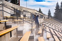 Custodian pressure washing stadium