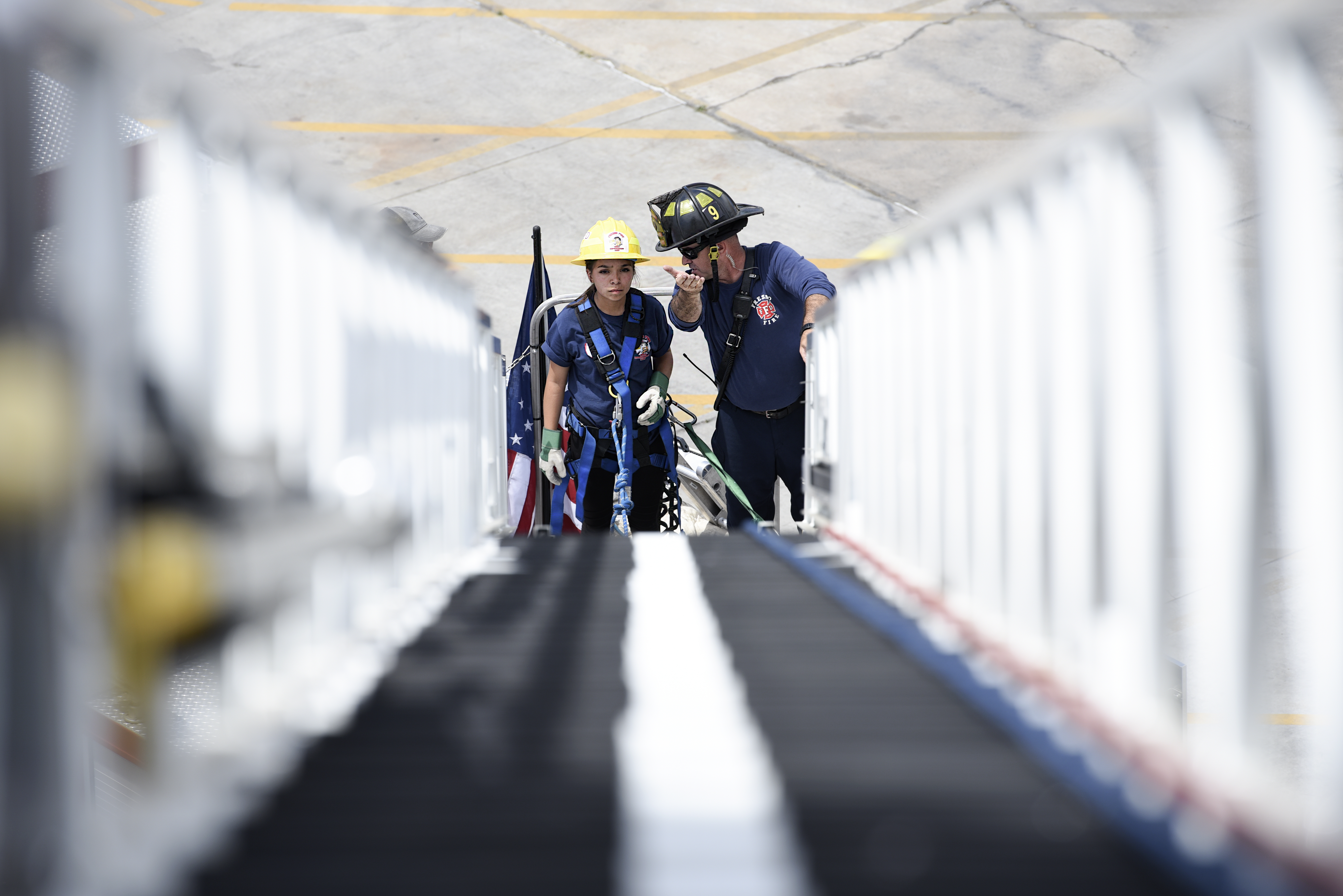 Student and Firefighter being shown ladder to climb up